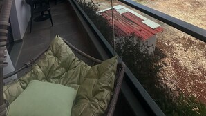 Un balcon donnant sur un chantier de construction et sur des bâtiments situés au loin.