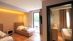 A hotel room with a bed, bedside table, and a view of the outdoors. - Hotel Citrus (Ksamil)