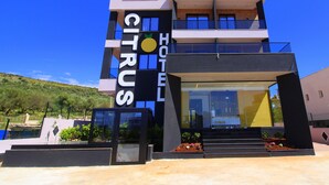 Un hôtel moderne avec une enseigne bien visible portant l’inscription « CITRUS HOTEL ».