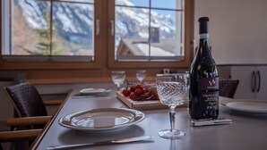 Een eettafel met een fles Valpolicella Ripasso Zeni wijn, een glas en een bord.