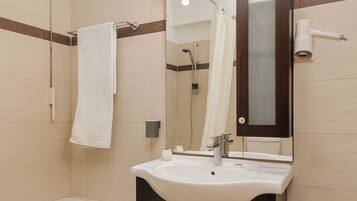 A modern bathroom with a bathtub, a sink with a mirror, and a showerhead.