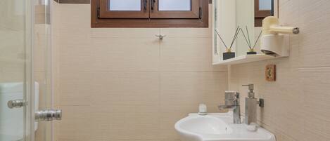 A bathroom with a toilet, sink, and shower.