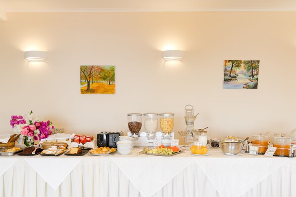 Una mesa de buffet con diversas opciones de comida y una decoración floral.