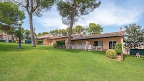 Il s’agit d’une propriété résidentielle dotée d’une pelouse bien entretenue, d’un patio aménagé avec du mobilier d’extérieur et d’un bâtiment à deux étages surmonté d’un toit en tuiles.