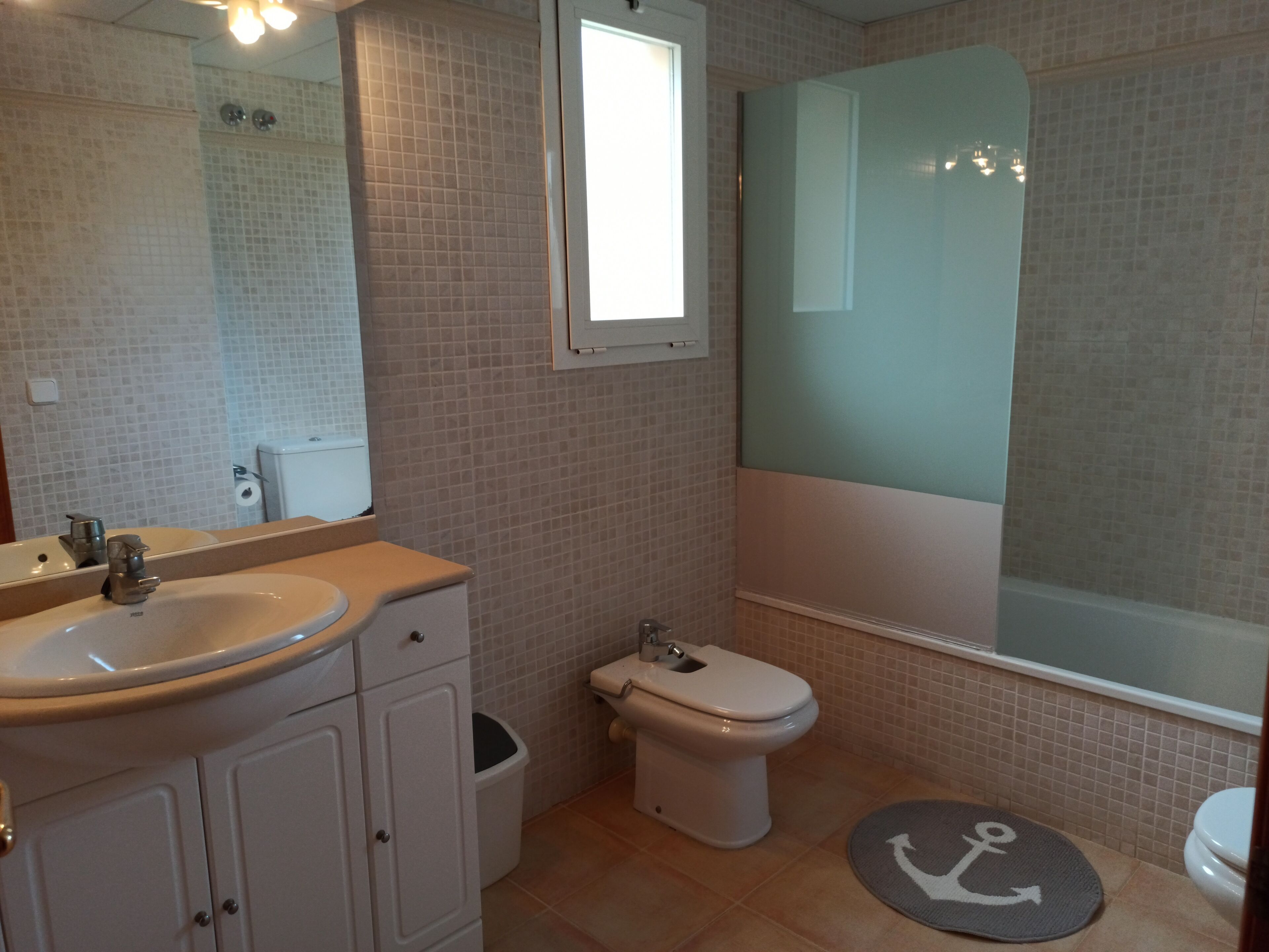 Un baño con lavamanos, inodoro y ducha.