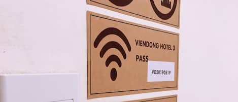 A wall-mounted sign with a no-smoking and no-drinking symbol, a Wi-Fi symbol, and a reception sign indicating 24-hour service.