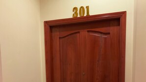Una puerta de madera con el número "301" encima.
