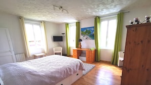 A bedroom with a bed, a desk, a chair, a wardrobe, and a painting on the wall. - vacation home   (Hugleville-en-Caux)