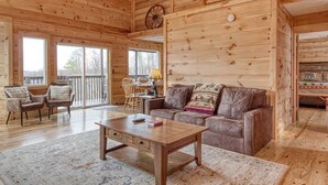 A spacious wooden cabin with a large living area, a dining table, and a cozy seating arrangement. - ⭐️Prime Location with Stunning Views, Hot Tub, Game Room⭐️ (Gatlinburg)