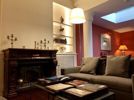 Una sala de estar acogedora con chimenea, libros y un sofá.