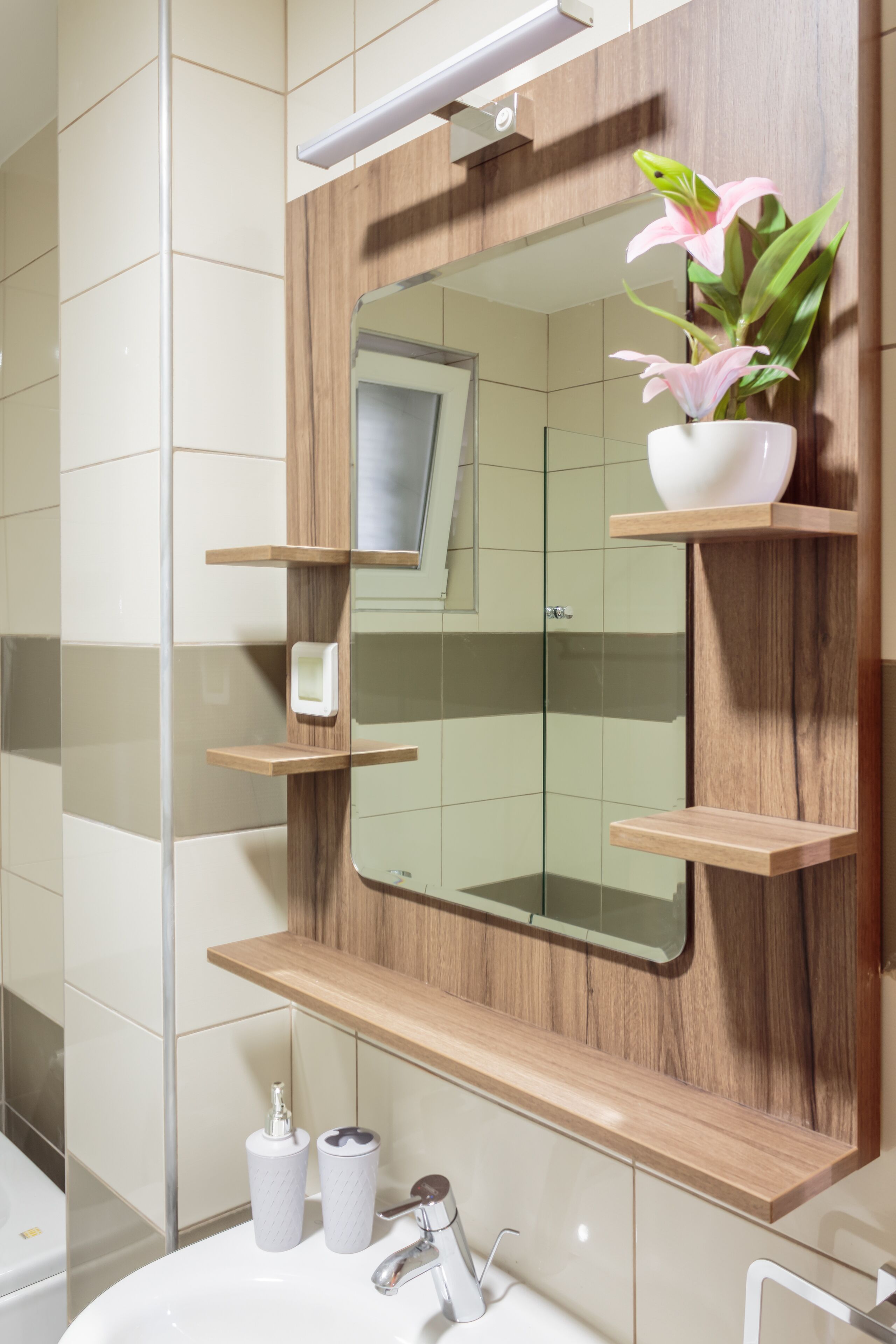 A bathroom with a wooden vanity, a mirror, and a sink.