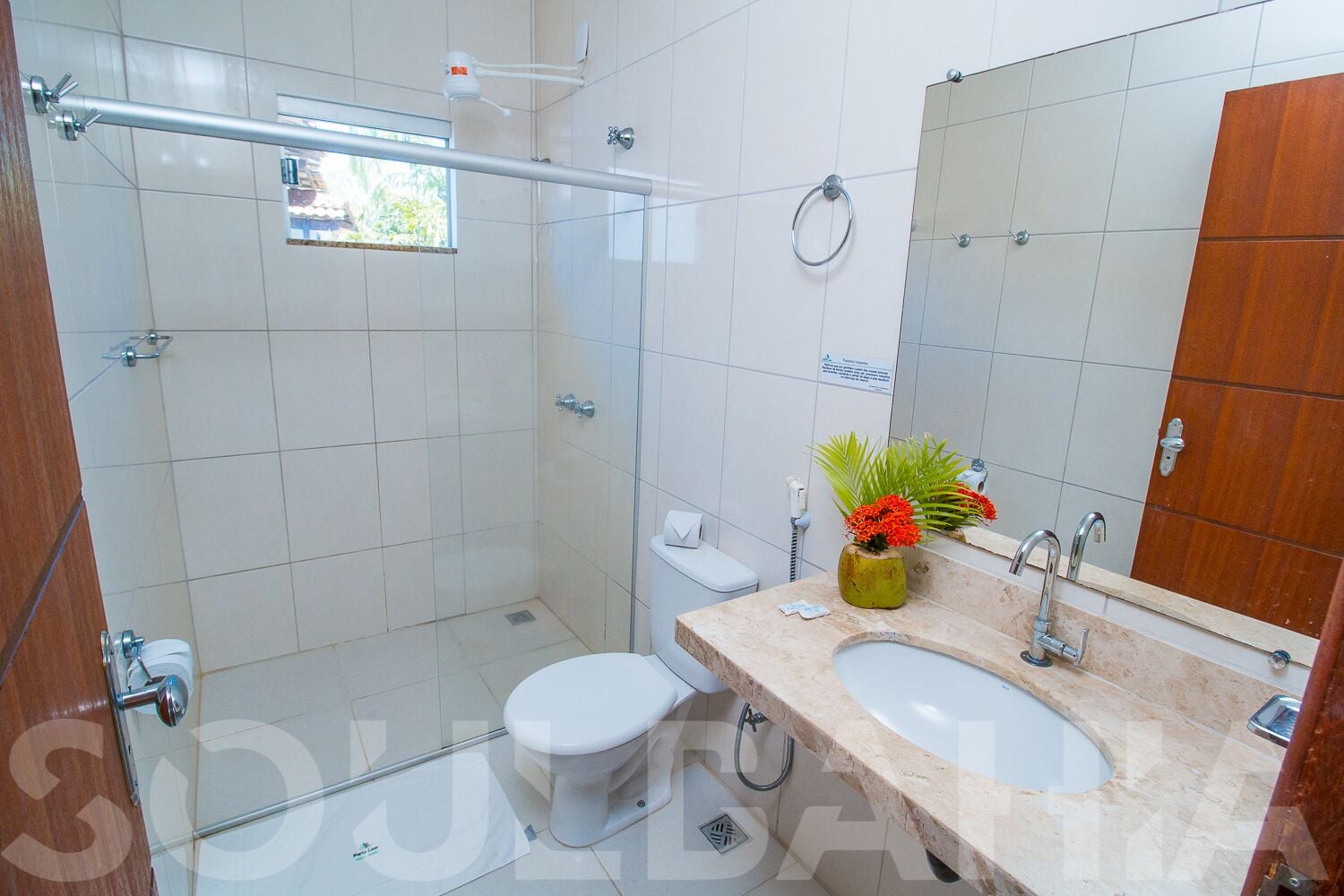 Une salle de bain moderne avec une douche à parois de verre, des toilettes, un lavabo et un miroir de coiffeuse.