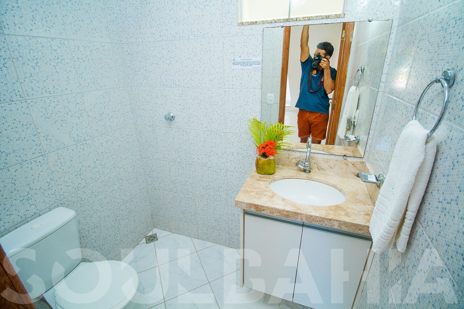 A modern bathroom with a toilet, sink, and mirror.