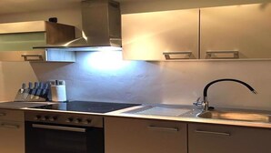 A modern kitchen with stainless steel appliances, a built-in oven, and a sink with a sleek faucet.