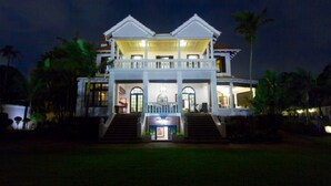 A large, two-story building with a balcony, a staircase leading to the entrance, and a well-lit facade. - Audacia Manor Boutique Hotel (Berea)