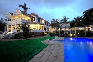 A large, two-story house with a swimming pool, surrounded by palm trees and a well-maintained lawn. - Audacia Manor Boutique Hotel (Berea)