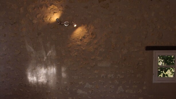 A hot tub in a room with a textured wall and a window. - Les Colonnes de Chanteloup (Amboise)