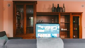 Un salon avec un téléviseur, des meubles en bois et un canapé.
