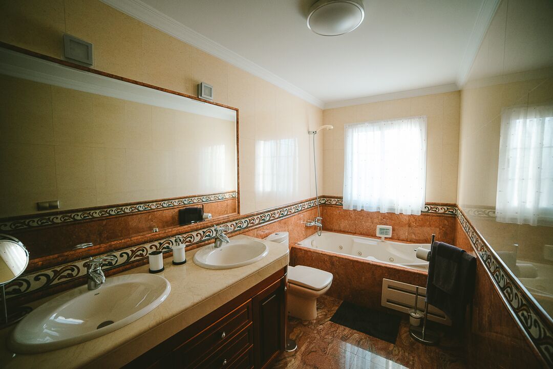 Une salle de bain avec deux lavabos, des toilettes et une baignoire.