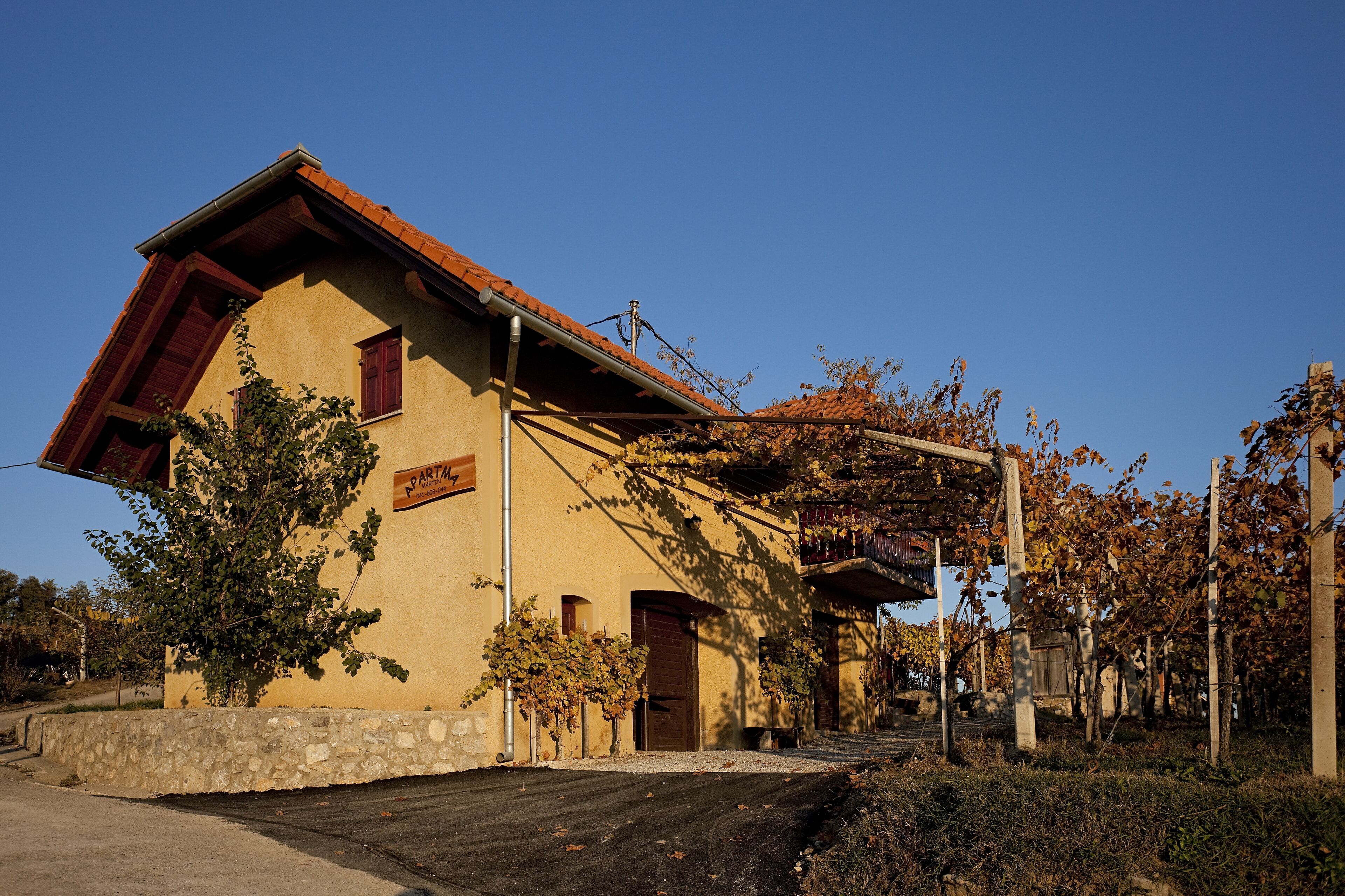 Un bâtiment avec des fondations en pierre, un toit en tuiles et une enseigne sur laquelle on peut lire « PARTIEL ».