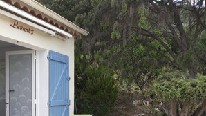 An outdoor dining area with a table set for two, a blue door, and a sign reading "Levant". - NEW: Air-conditioned apartment with wifi (Le Lavandou)