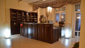 A spacious room with a central wooden bar, a large cabinet with glassware, and a window with curtains. - Jardin Hotel Belgrade (Belgrade)