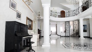 A grand lobby with a piano, a chandelier, and a staircase. - Jardin Hotel Belgrade (Belgrade)