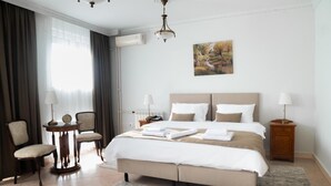 A hotel room with a large bed, two bedside tables, a chair, and a painting on the wall. - Jardin Hotel Belgrade (Belgrade)