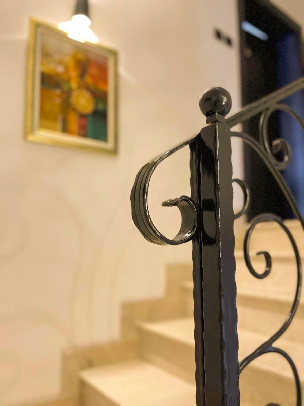 A staircase with a metal handrail and a wall-mounted picture.