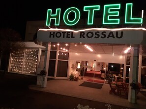 A hotel with a neon sign reading "HOTEL ROSSAU" and a well-lit entrance. - Edit Pension Rossau (Rossau)