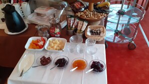 A table with various food items and condiments, including fruits, spreads, and a coffee pot. - Edit Pension Rossau (Rossau)