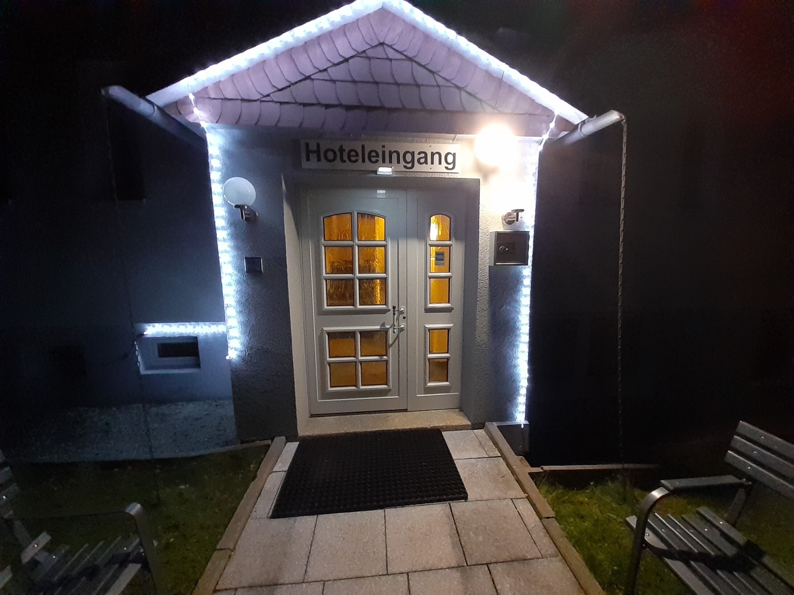 Entrada de hotel com uma placa que diz 'Hoteleingang'.