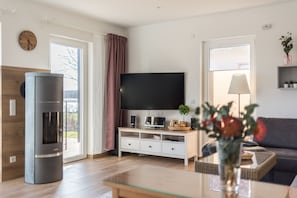 Ein modernes Wohnzimmer mit Flachbildfernseher, Kamin und einer Couch.