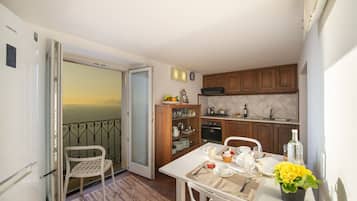 Enjoy a scenic view from the balcony of this well-appointed apartment, featuring a dining area and kitchen with modern appliances.