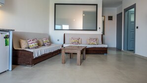 A modern living room with a sofa, a coffee table, and a large mirror on the wall.