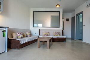 Una sala de estar moderna con un sofá, una mesa de centro y un espejo grande en la pared.