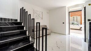 A modern interior with a marble staircase, a sofa, and a door leading outside. - 4000 Casa Chiaraluna by Barbarhouse (Porto Cesareo)