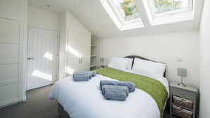 A bedroom with a bed, two skylights, a wardrobe, and a nightstand. - Beech Cottage - UK11845 (Carkeel, near Saltash)