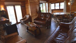 Un intérieur de chalet chaleureux avec des murs en bois, des meubles en cuir et un coin repas.