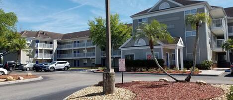 A multi-story building with a parking lot in front.