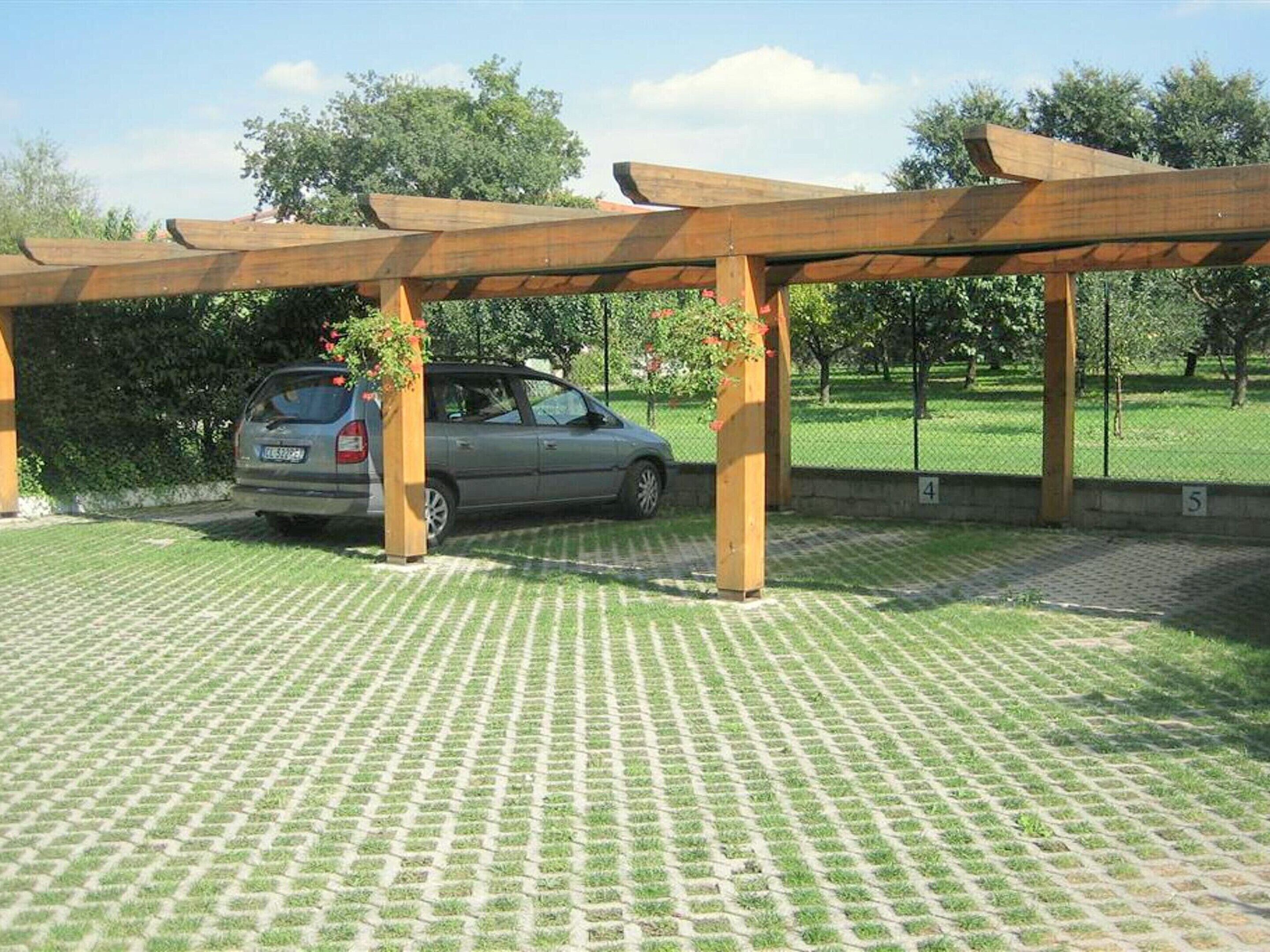 Egy fedett, szabadtéri terület, melynek alatta egy autó parkol.
