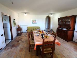A dining area with a checkered tablecloth, wooden chairs, and a buffet cabinet. - Belvilla by OYO Stalla (Bagnoregio)