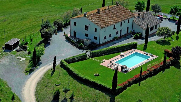 A large white building with a tiled roof, surrounded by a well-maintained lawn and a swimming pool. - Peaceful Pienza Garden Escape (Pienza)