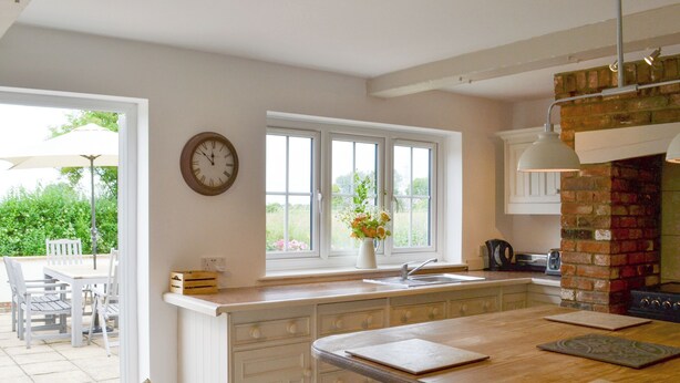 A kitchen with a wooden countertop, a sink, and a brick oven. There is a window with a view of greenery outside. - 5 bedroom accommodation in Tilney St Lawrence, near Kings Lynn (Tilney St Lawrence, near Kings Lynn)