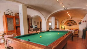 A pool table in a room with arched ceilings and a cozy seating area. - Belvilla by OYO Olmi (Casole d'Elsa)