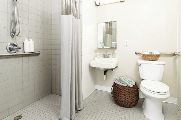 A bathroom with a shower, toilet, sink, and a mirror. - InTown Suites Extended Stay Houston TX - Highway 6 (Houston)