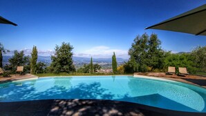 Une piscine offrant une vue sur les montagnes lointaines et un ciel dégagé.