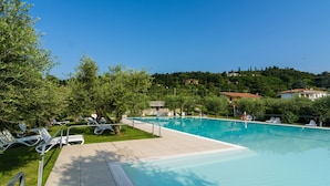 Una piscina con sillas de descanso y una vista despejada del paisaje circundante.