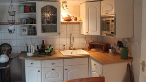 A compact kitchen with white cabinets, a sink, a microwave, and a toaster. - Quaint Holiday Home in Schwaan near Lake (Schwaan)