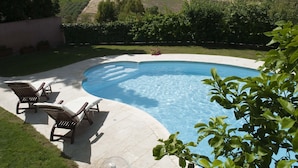 A swimming pool with lounge chairs, surrounded by a landscaped garden and a view of vineyards in the background. - Holiday Home in Buseto Near San Vito Lo Capo (Buseto Palizzolo)